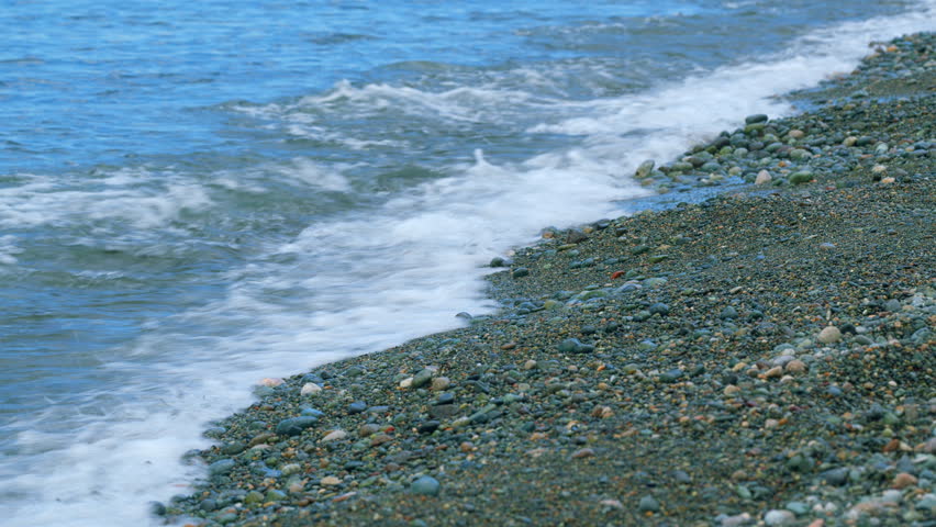 Round Sea Pebbles Are Washed By Clean Transparent Sea Waves. Small Sea Foam Waves. Royalty-Free Stock Footage #3455148597