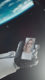 Vertical Screen: Excited Man in a Space Suit Talking on a Phone with His Girlfriend in Outer Space Next to a Satellite. Astronaut Having a Video Conversation with a Young Female on a Smartphone
