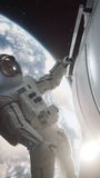 Vertical Screen: Young Male Astronaut Performing a Spaceship Maintenance and Check Up in Outer Space. Trained Professional in a Space Suit is on a Extravehicular Mission Outside the Spacecraft