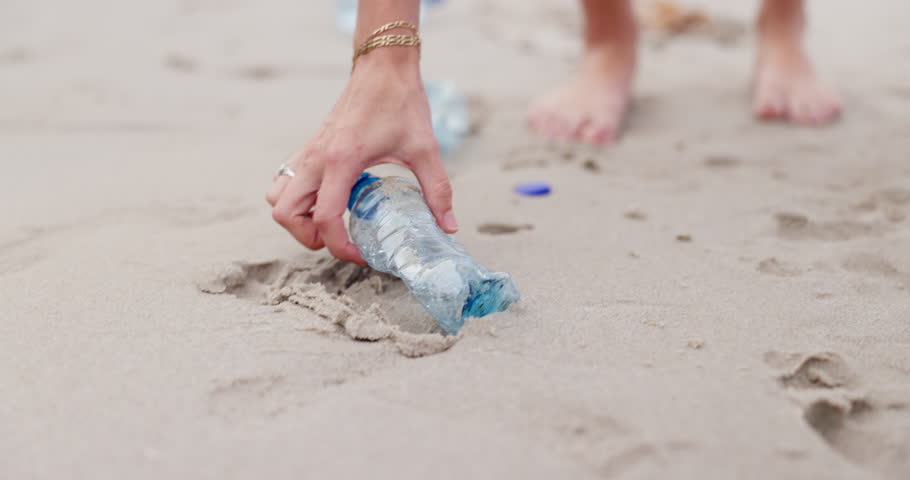 People, hands and beach with bag for recycling plastic bottle, cleaning or saving the planet in nature. Closeup of volunteer picking up rubbish, dirt or garbage of waste on sandy shore or ocean coast Royalty-Free Stock Footage #3455205451