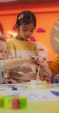 Vertical Screen: Adorable Multiethnic Girls Using Watercolor to Create Colorful Paintings on Paper. Cheerful Female Teacher Spending Productive Time in Preschool, Teaching Kids to Paint in Art Class