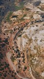 Unusual colorful landscape of Travertine Hot Springs, California, USA. Few cars parked at the road end. Aerial view. Vertical video.