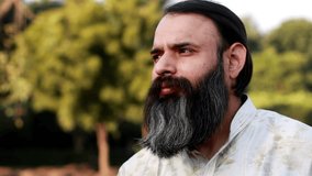 Thoughtful beard men of Indian ethnicity video portrait outdoor in nature during sunset.