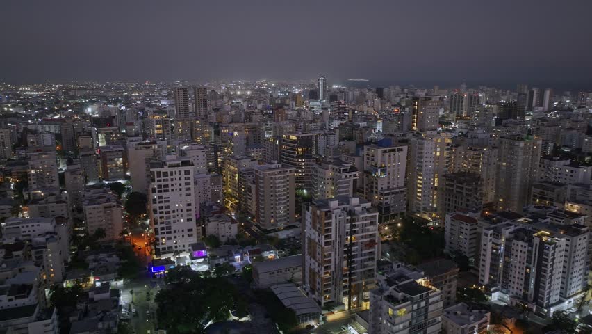 Santo Domingo Town by night. Beautiful lighting city with tower and high rise buildings. Aerial orbit wide shot. Capital of Dominican Republic.