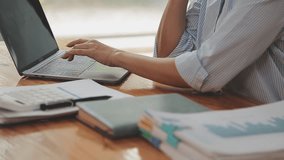 Asian Businesswoman Using laptop computer and working at office with calculator document on desk, doing planning analyzing the financial report, business plan investment, finance analysis concept. - Powered by Shutterstock - Get 15% off with code: PIKWIZARD15