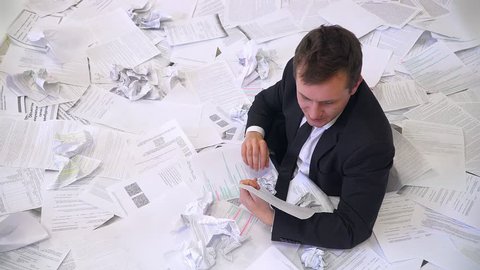 the man in the office drowning in paper