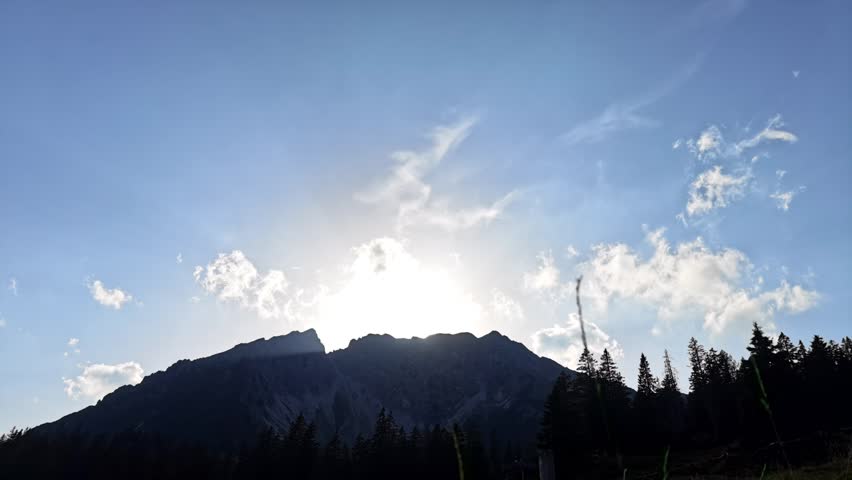 Timelapse of Sun going down behing Mountain with Clouds Flying above in Austrian Alps Europe
