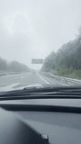 First person view, FPV, from dashcam of car driving in the Sierra Nevada mountains, Granada, Andalusia, Spain, Europe, in the rain. Road trip vertical video in POV from inside vehicle