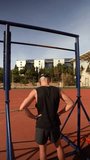 Vertical video of a young boy performing barbell pull-ups. Concept of preparation and physical fitness.