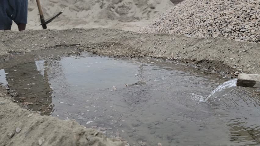water coming out of a pipe to mix cement and gravel at a construction site. Construction Works. Mix cement with water, sand and coral stone. Royalty-Free Stock Footage #3455606441