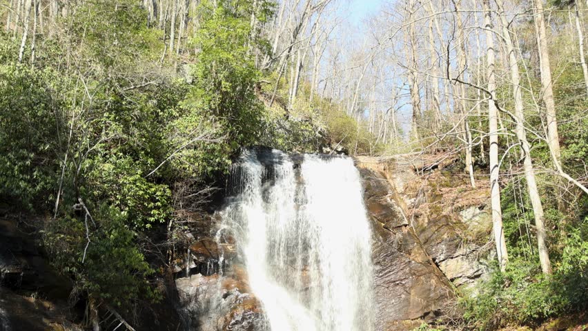 footage of the rushing waters of Smith Creek and waterfall at Anna Ruby Falls with rocks and lush green trees and plants in Helen Georgia USA