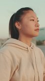 VERTICAL VIDEO, girl in sportswear doing workout, stretching at morning time on modern buildings background
