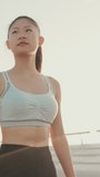 VERTICAL VIDEO, girl in sports top walking outside at morning time