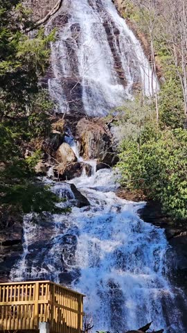 footage of the rushing waters of Smith Creek and waterfall at Anna Ruby Falls with rocks and lush green trees and plants in Helen Georgia USA
