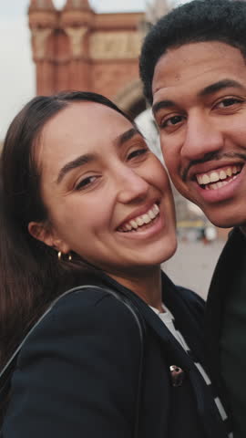 Vertical video, Happy couple taking selfie with city park and historical buildings in background.