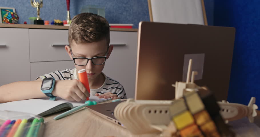 Diligent Young Student Doing Homework with Laptop and Stationery