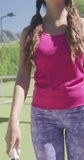 Vertical video of portrait of happy caucasian woman with tennis racket on sunny day. Free time, sport and activity.