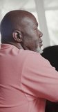 Vertical video of thoughtful senior african american man in slow motion. Spending quality time at home, retirement and despair.
