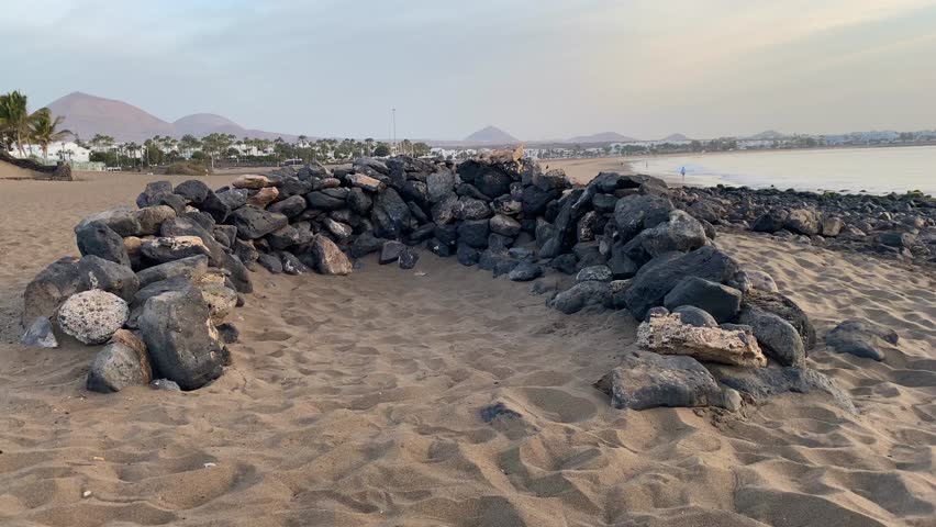 Typical stone wind break on the beach, Puerto del Carmen, Canary Islands, Spain