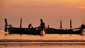 Travel video Group of silhouette long tail boat and The fisherman are maintenance ship. After the boats go out, such as catching the fish. Trips are made every day with golden light before sunset