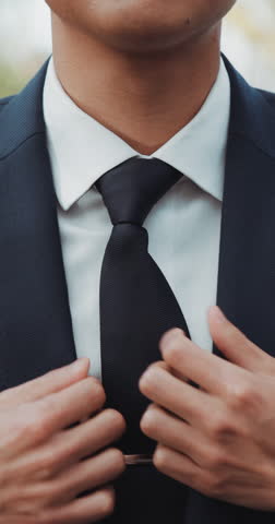 Hands, wedding and tie with a man getting reading for a marriage ceremony outdoor at an event closeup. Fashion, watch and vertical with a groom dressing in a smart or formal suit to get married