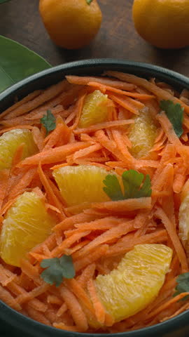 Orange and grated carrot salad. Moroccan traditional cuisine. Table spin. Vertical video. Royalty-Free Stock Footage #3456107155