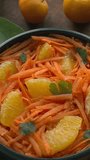 Orange and grated carrot salad. Moroccan traditional cuisine. Table spin. Vertical video.