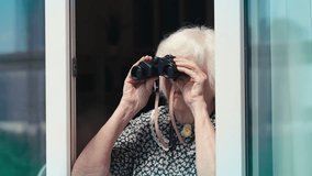 Humorous elderly woman watching people on the street using binoculars, spying - Powered by Shutterstock - Get 15% off with code: PIKWIZARD15