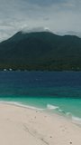 White Island with clear sea water and greenish waves. Camiguin, Philippines. Vertical video.