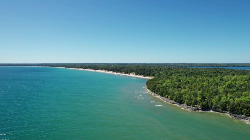 drone shot flying over lake Michigan towards whitefish dunes state park