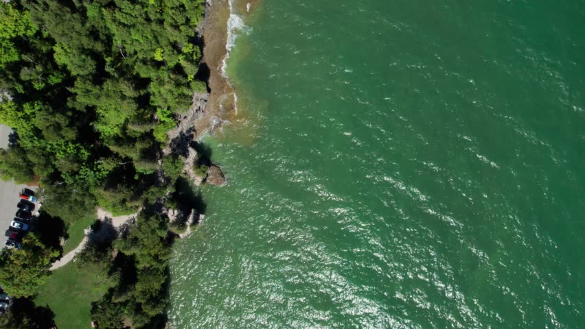 Drone aerial view looking straight down on waves crashing on the shoreline