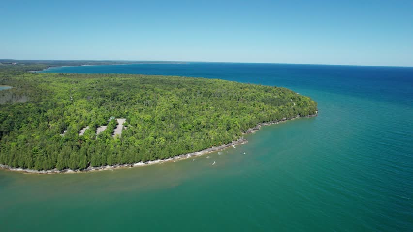 Drone aerial shot of a pine tree forest on the shores of lake Michigan