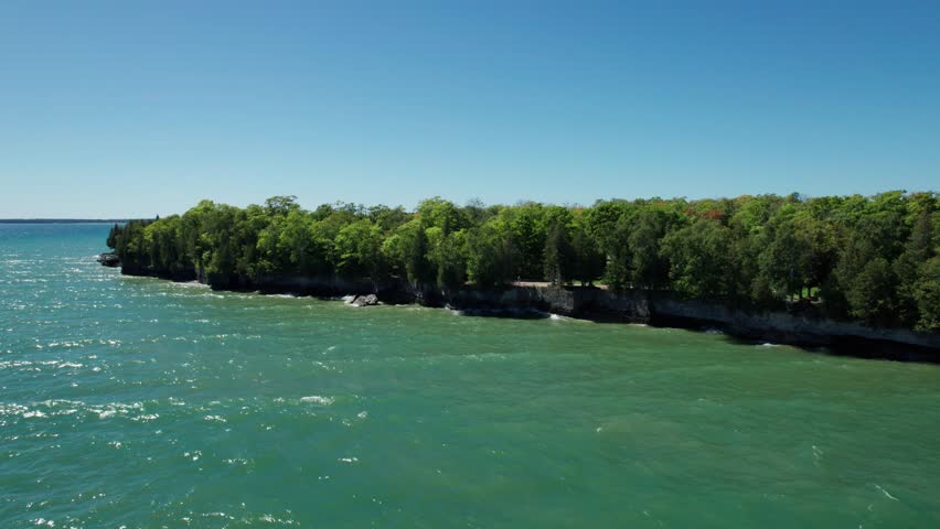 Drone shot of lake Michigan waves crashing into the shores of door county