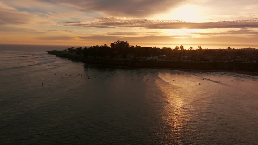 Hundreds of surfers in the pacific ocean in Santa Cruz, California during sunset