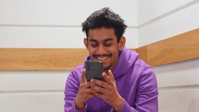 Happy Asian man talking and using smartphone, front view