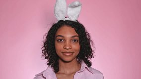 pink easter footage with cute happy girl in bunny ears winking and sending a kiss. promotion and advertisment concept - Powered by Shutterstock - Get 15% off with code: PIKWIZARD15