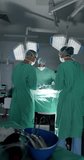 Vertical video of diverse surgeons with face masks during surgery in slow motion. Medicine, health and care.
