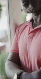 Vertical video of thoughtful senior african american man in slow motion. Spending quality time at home, retirement and despair.