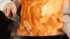 Chef cooking flambe vegetables mix on wok frying pan close-up. Color hot and sweet peppers on fire throwing them on pan. Restaurant Food concept - Powered by Shutterstock - Get 15% off with code: PIKWIZARD15