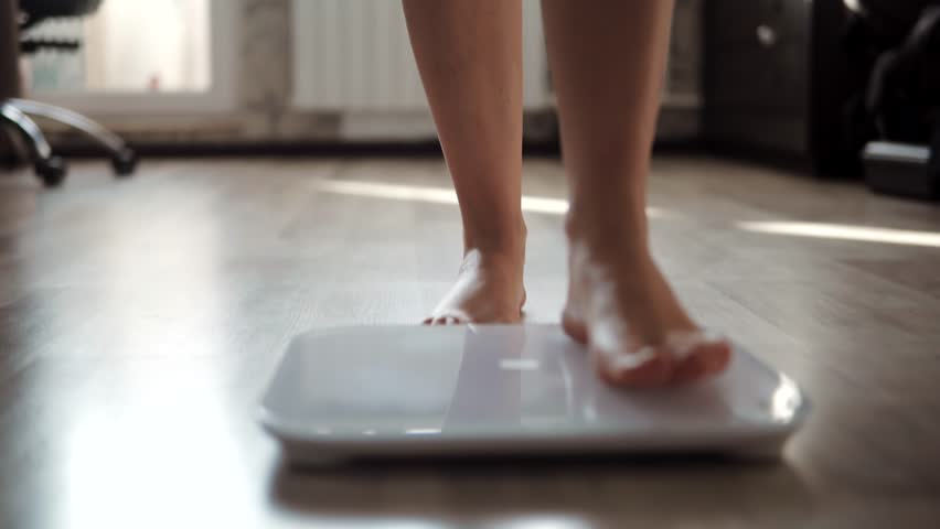 Weight Lose Scales Measure Weight. Girl Legs Bathroom Scale. Fitness Diet Slimming Woman Feet Standing Weighing Scales Slimming. Dieting BMI Weight Loss. Barefoot Measuring Body Fat Overweight At Diet
