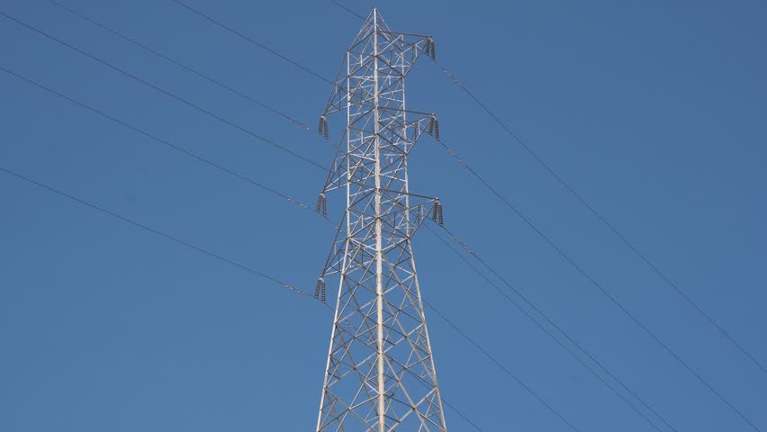 High voltage Electricity tower. Visualization of current in wires. High voltage tower concept. Electrical Transmission Tower against the blue sky. Prores of high voltage pole and moving clouds. 4K Royalty-Free Stock Footage #3456402663
