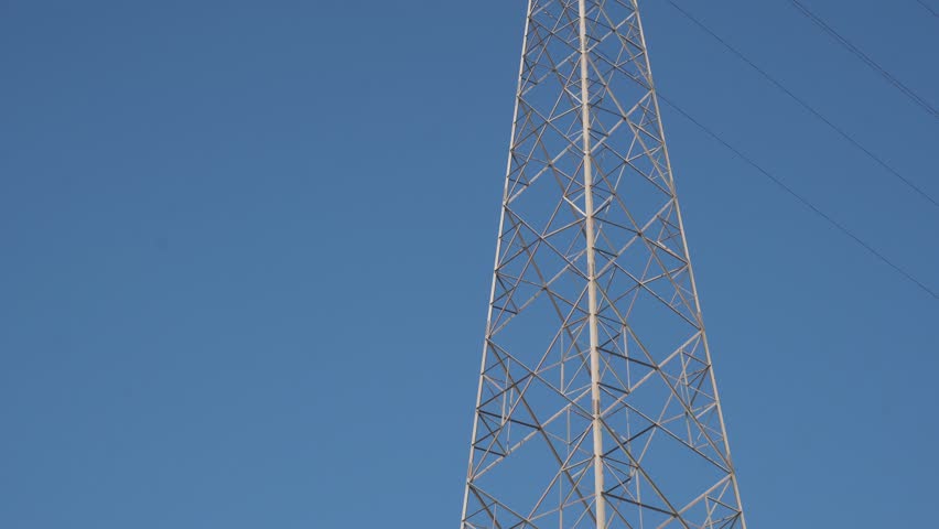 High voltage Electricity tower. Visualization of current in wires. High voltage tower concept. Electrical Transmission Tower against the blue sky. Prores of high voltage pole and moving clouds. 4K Royalty-Free Stock Footage #3456406931