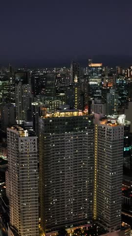 Makati Skyline. Night view of High Rise Towers and Hotels. Metro Manila. Philippines. Vertical view.