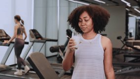 Attractive fitness African American woman finishing workout and drinking protein milk shake vitamins after training. Bodybuilding. Healthy lifestyle. - Powered by Shutterstock - Get 15% off with code: PIKWIZARD15