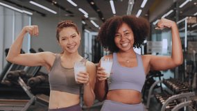 Asian and African American woman finishing workout and drinking protein milk shake vitamins after training. Bodybuilding. Healthy Friend lifestyle. - Powered by Shutterstock - Get 15% off with code: PIKWIZARD15