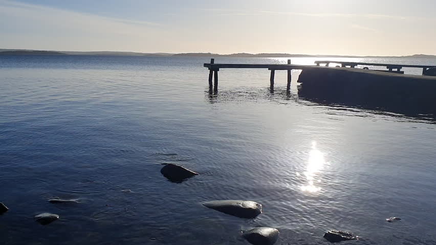One warm evening the sun sparkles and the old bridge goes on the blue sea.
