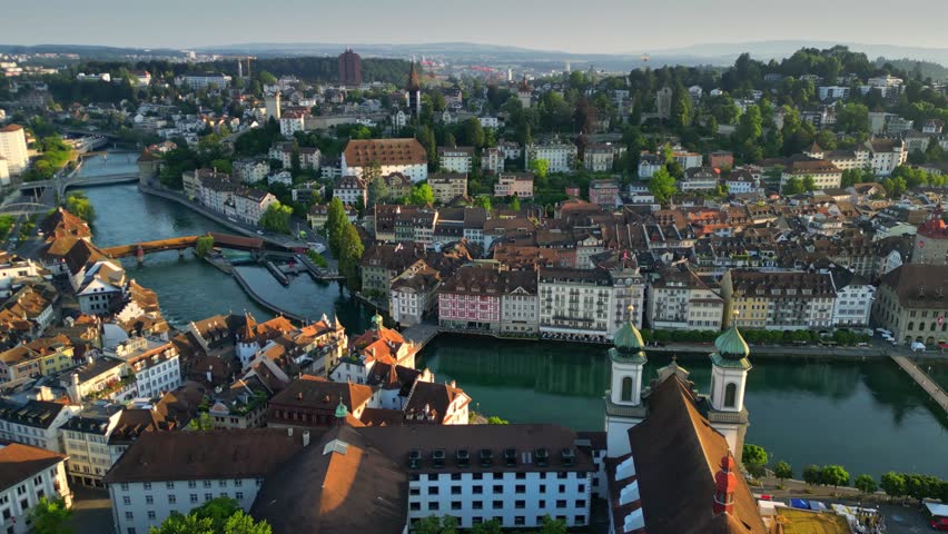 Aerial morning view of Lucerne old town and Reuss river. View of Jesuitenkirche Hl. Franz Xaver church and old houses in Luzern city center, Switzerland, shot at sunrise