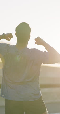 Man, winner and sunset running, fitness and lens flare by achievement and success for training. Happy runner, athlete and celebrate in energy, health and workout in sportswear, exercise and goals