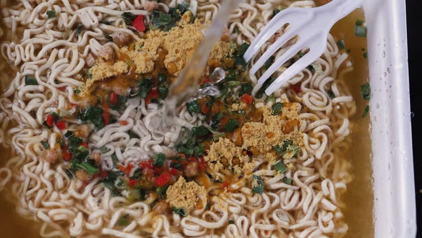 Pour water into instant noodles: Quick treat. Cooking instant noodles. slow motion. vermicelli quick cooking soup macro Royalty-Free Stock Footage #3456495903