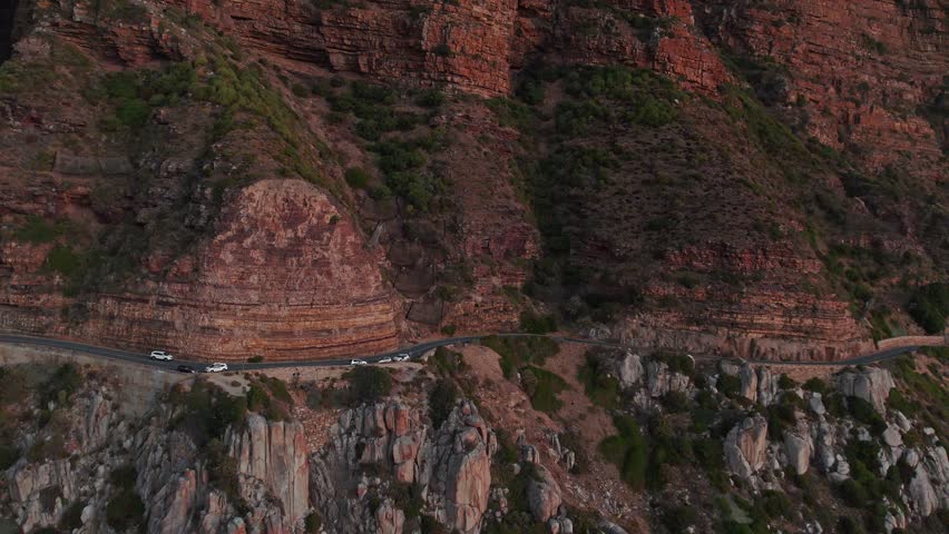 Vehicles Driving On Chapman's Peak Drive, Cape Town, Africa At Sunset - Aerial Drone Shot